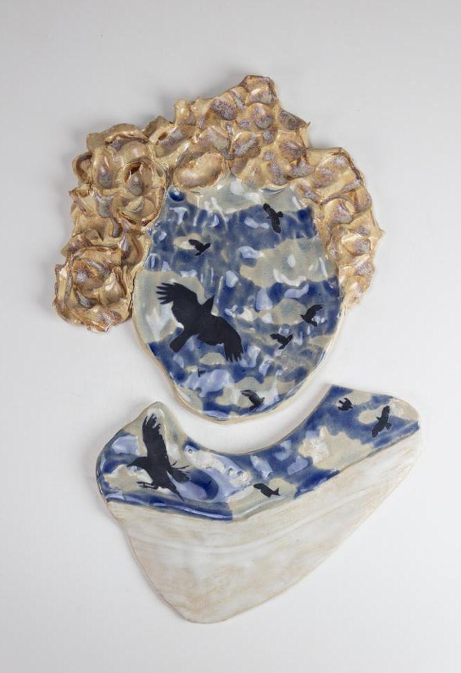 “Self Portrait”: A ceramic piece of the artist's head, instead of a face there are birds and a cloudy sky.